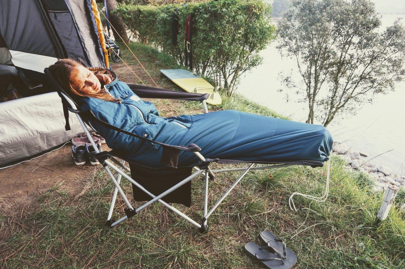 Frau mit Schlafsack auf Campingstuhl